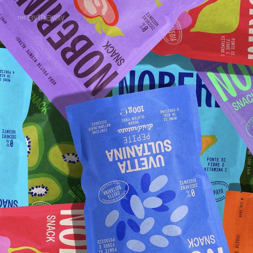 Stand up paper pouch mockup featuring multiple colorful snack packages with bold text and fruit illustrations arranged in a flat lay.