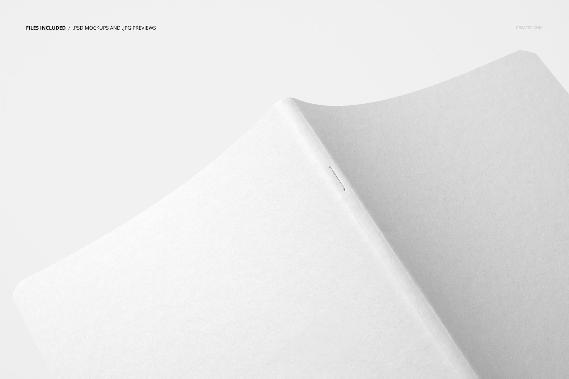 Angled top view of a plain open notebook mockup with smooth white pages and minimalistic design on a neutral surface.