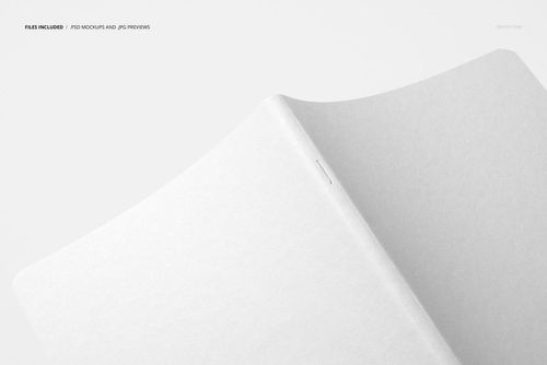 Angled top view of a plain open notebook mockup with smooth white pages and minimalistic design on a neutral surface.
