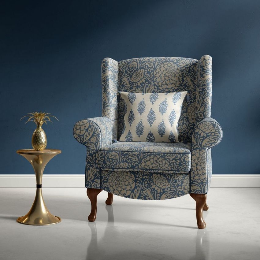 Retro velvet armchair mockup featuring a blue and white floral pattern, paired with a matching cushion and gold side table.