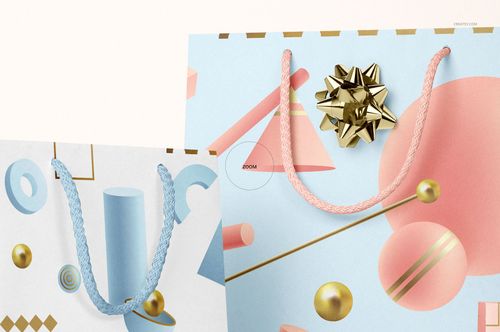 PSD mockup featuring two gifting paper bags with colorful geometric patterns, braided rope handles, and a shiny gold bow.