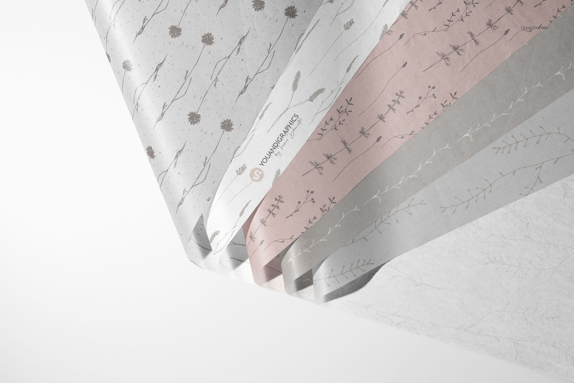 Tissue paper mockup set featuring multiple sheets with delicate flower and leaf designs in soft gray and pink shades.