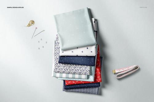 Assorted fabric stack mockup featuring light blue, navy, and patterned textiles, viewed from above with pins and tape measure.