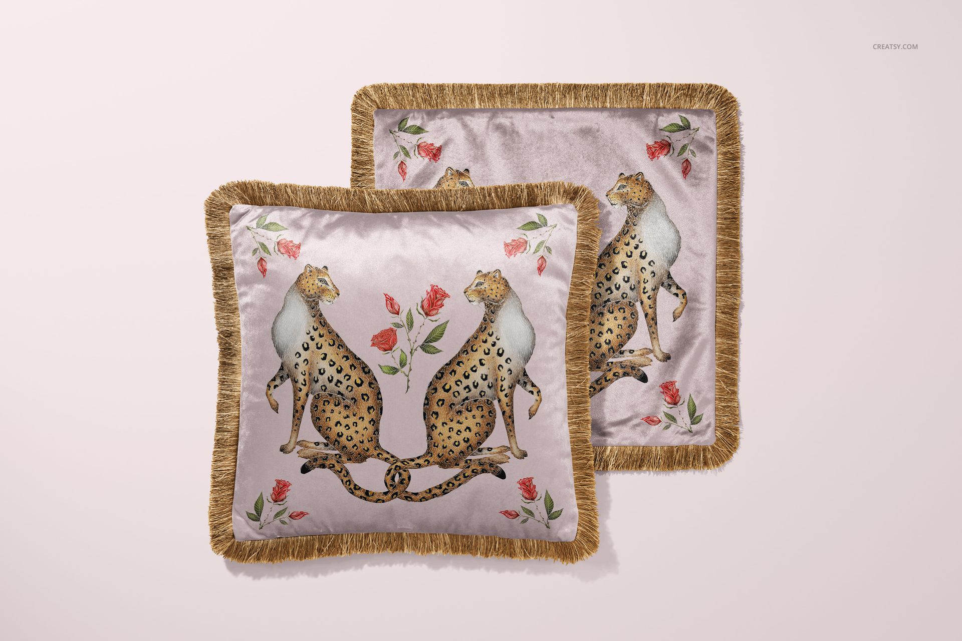 Fringed velvet cushion mockup displaying a symmetrical leopard and rose pattern on a soft pink background.