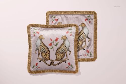 Fringed velvet cushion mockup displaying a symmetrical leopard and rose pattern on a soft pink background.