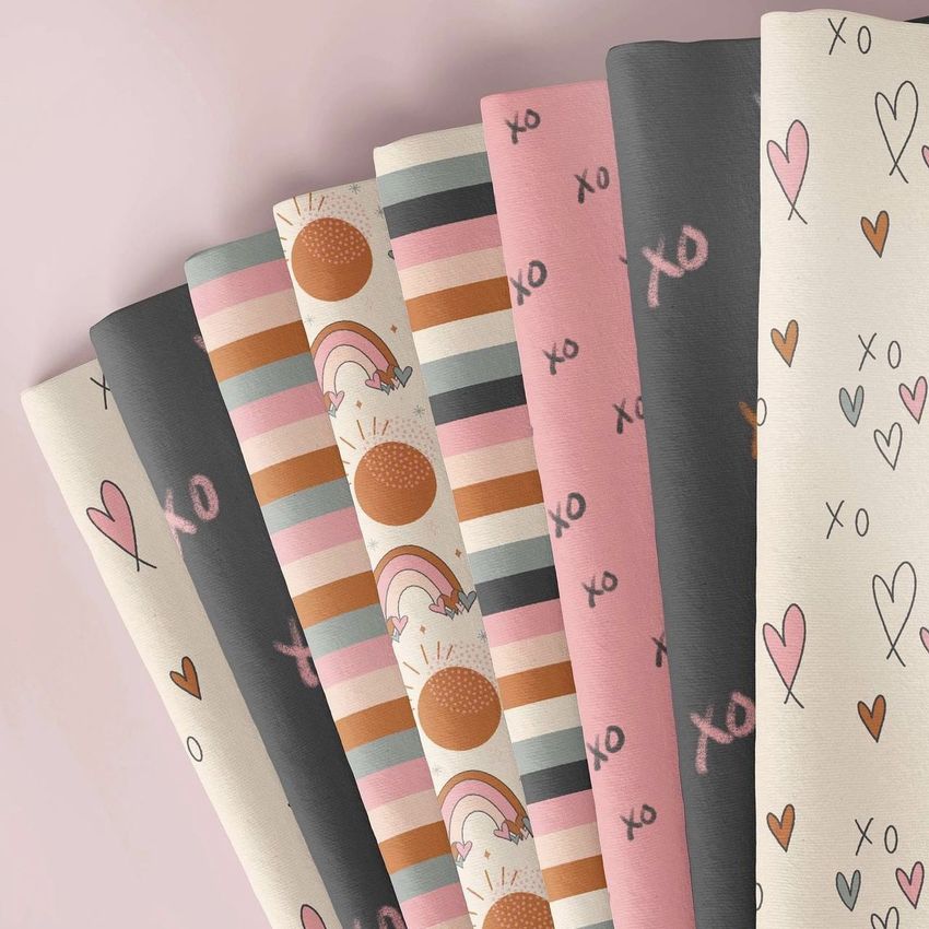 Folded fabrics mockup featuring seven pieces with playful Valentine-themed patterns in pink, gray, and cream tones.