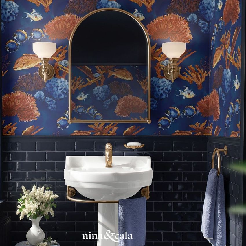 Vintage retro bathroom mockup featuring a white sink, gold fixtures, and coral reef themed wallpaper in blue and orange tones.