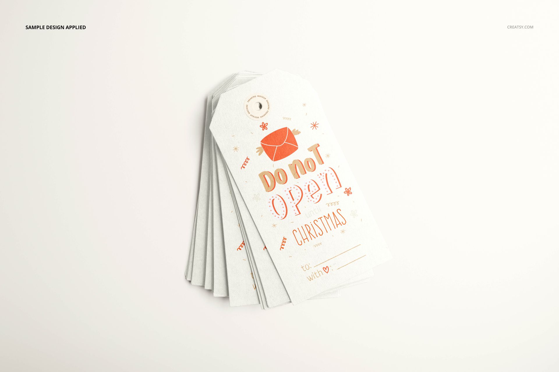 Paper labels mockup set arranged in a fanned stack, displaying Christmas-themed design in orange and white.