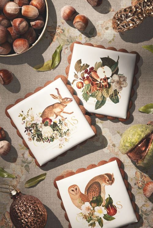 PSD mockup showing three decorated gingerbread cookies on a textured surface with nuts, leaves, and ornaments.
