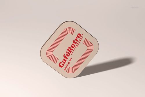 Single square wooden coaster mockup featuring a beige base, red geometric lines, and vintage text, shown at a tilted angle.