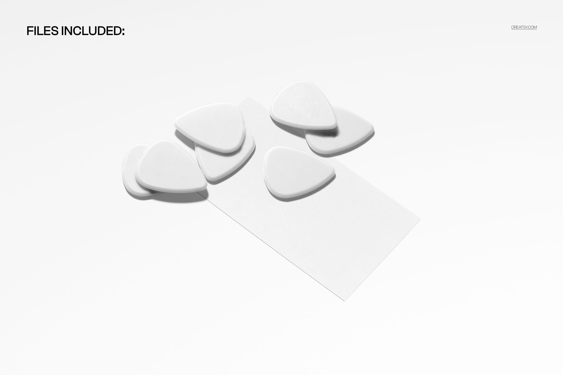 Front view of a guitar picks packaging mockup featuring several white guitar picks and a blank business card on a white background.