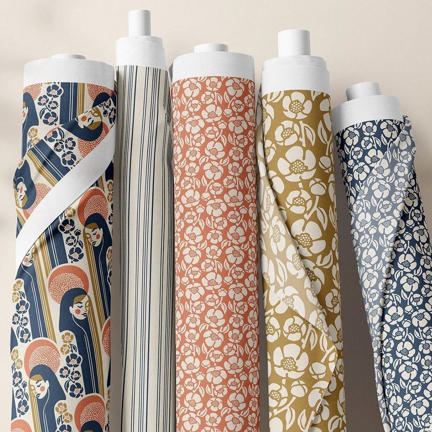 Fabric rolls mockup featuring five upright rolls with various floral and striped patterns in muted blue, gold, and peach tones.