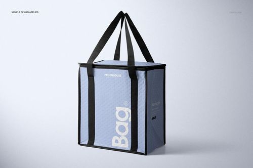 PSD mockup of a square-shaped insulated cooler bag in light blue with black straps, shown from a front side angle.