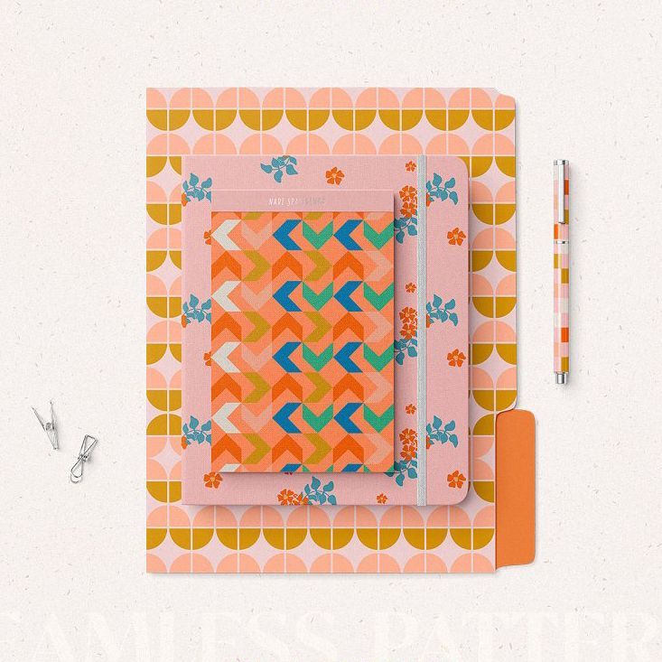 Stationery set mockup featuring patterned folders, notebooks, and a pen arranged on a light surface with geometric and floral designs.