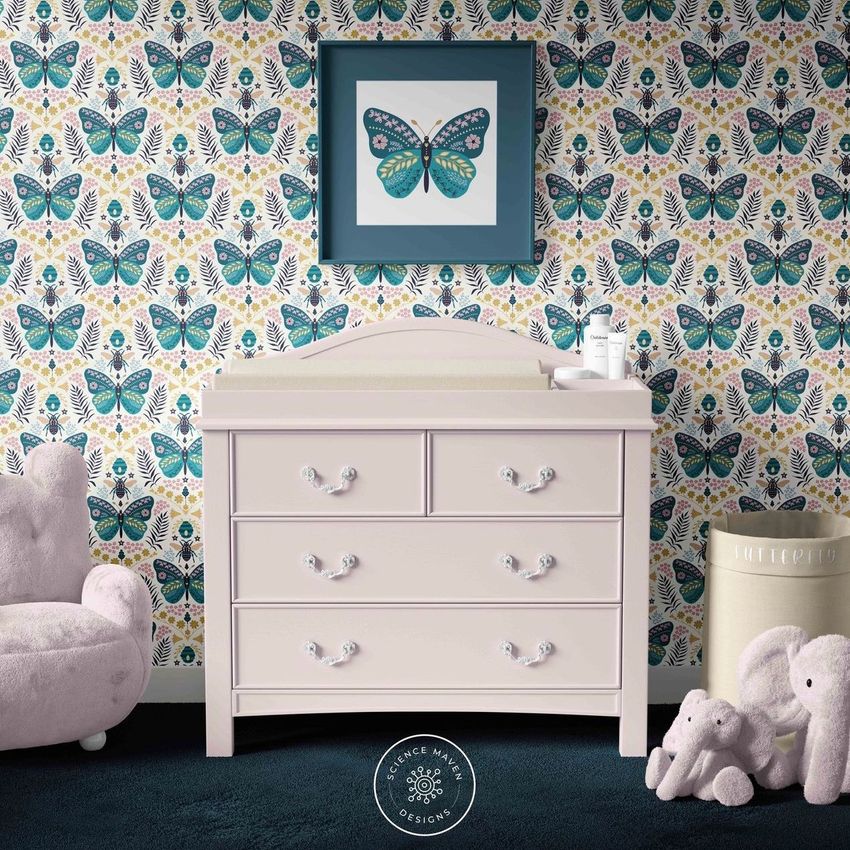 Baby room changing pad mockup showing a white dresser with a changing pad, butterfly wallpaper, and plush toys on the floor.