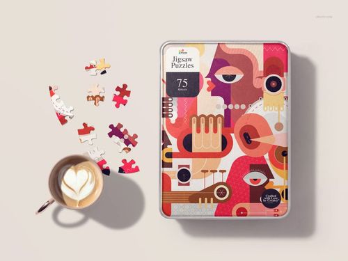 Heart-shaped jigsaw puzzle mockup with abstract colorful design, shown in a metal tin next to loose pieces and a coffee cup.