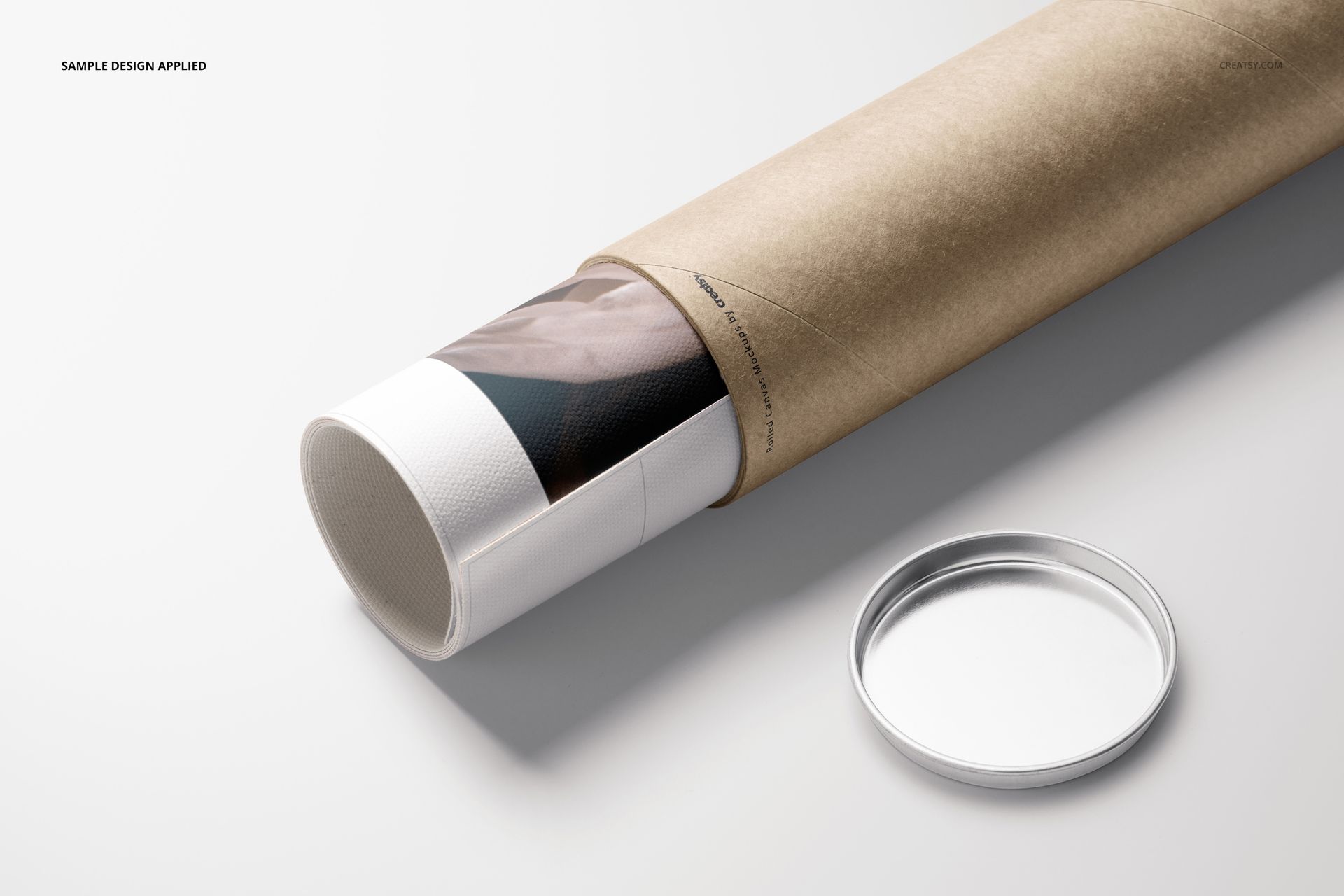 Front view of a rolled canvas print mockup emerging from a kraft paper tube, metal cap resting beside on white background.