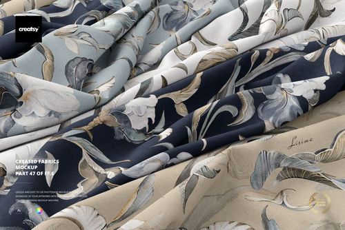 PSD mockup of multiple folded fabrics with elegant floral motifs in various colors, displayed in a close-up perspective.