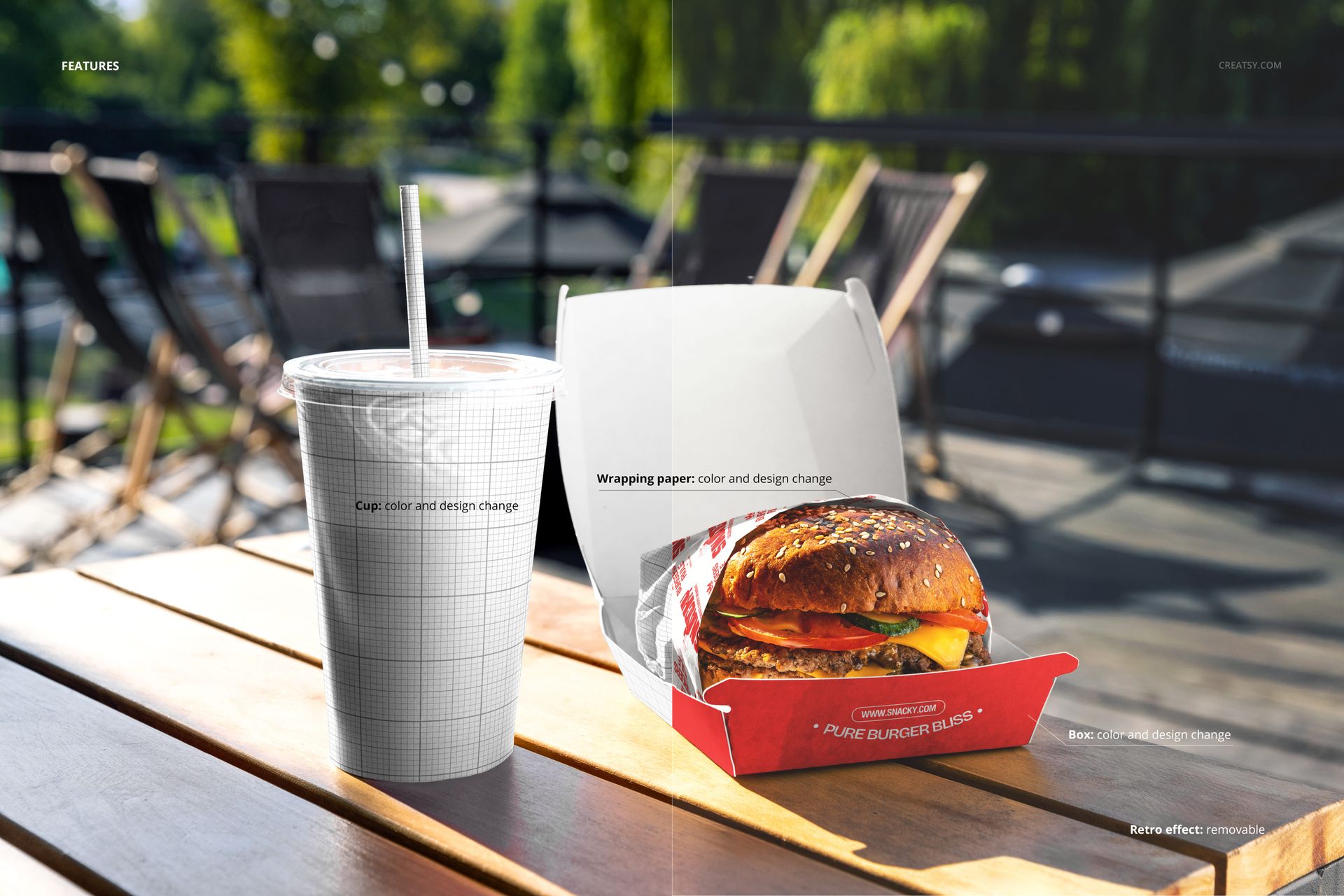PSD mockup showing a wrapped burger in a red box and a large drink cup with grid pattern on an outdoor table.