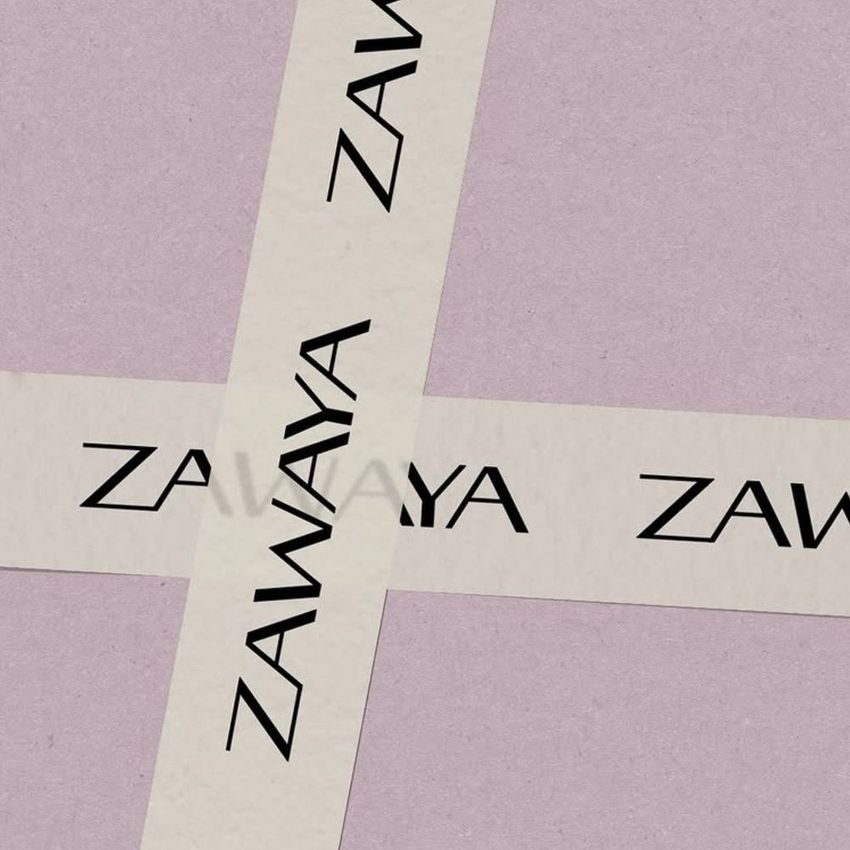 Packaging tape mockup featuring two crossing strips on a textured lavender background, each printed with bold black text.