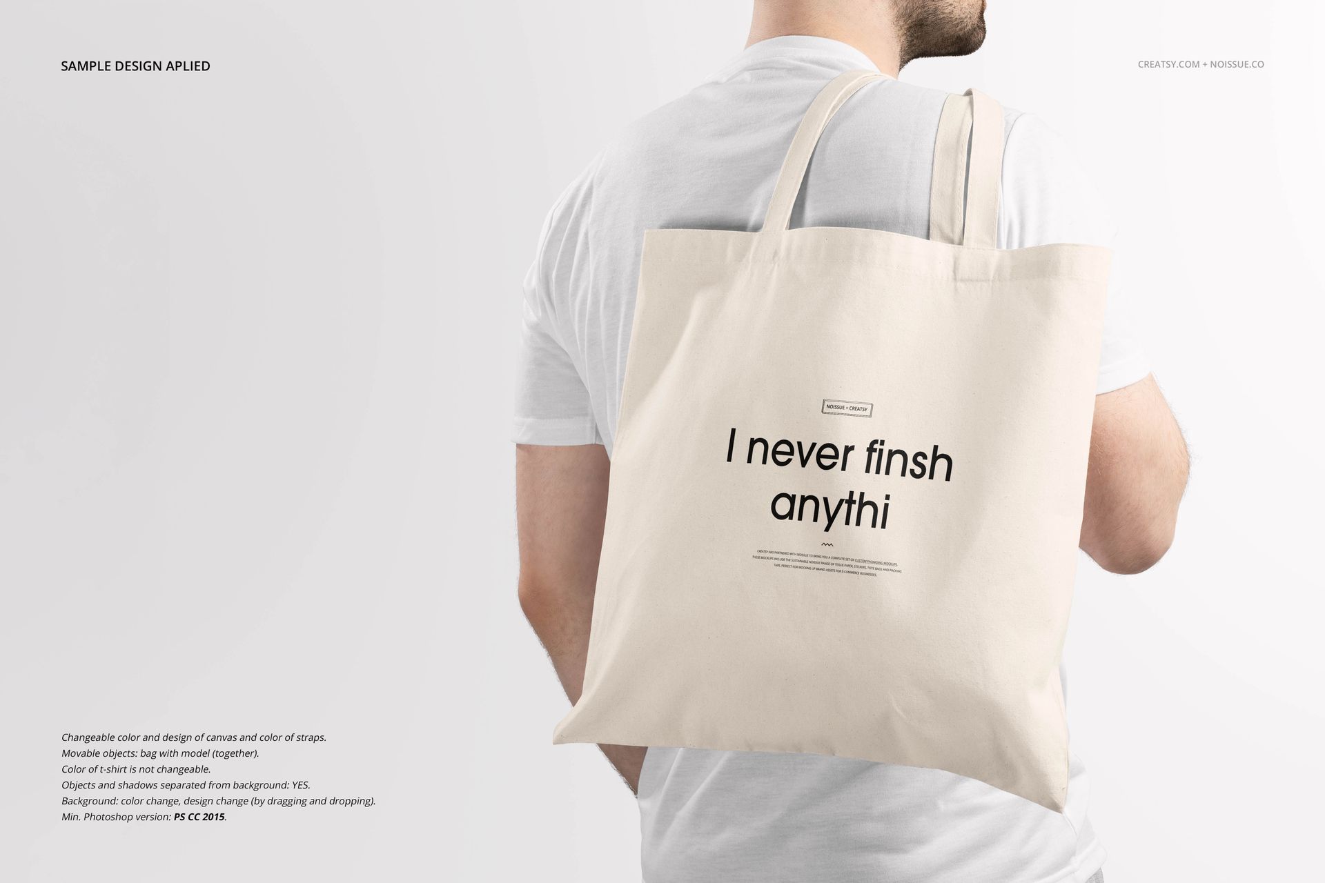 Front view of a beige tote bag mockup with black text, held by a person wearing a white t-shirt against a light background.