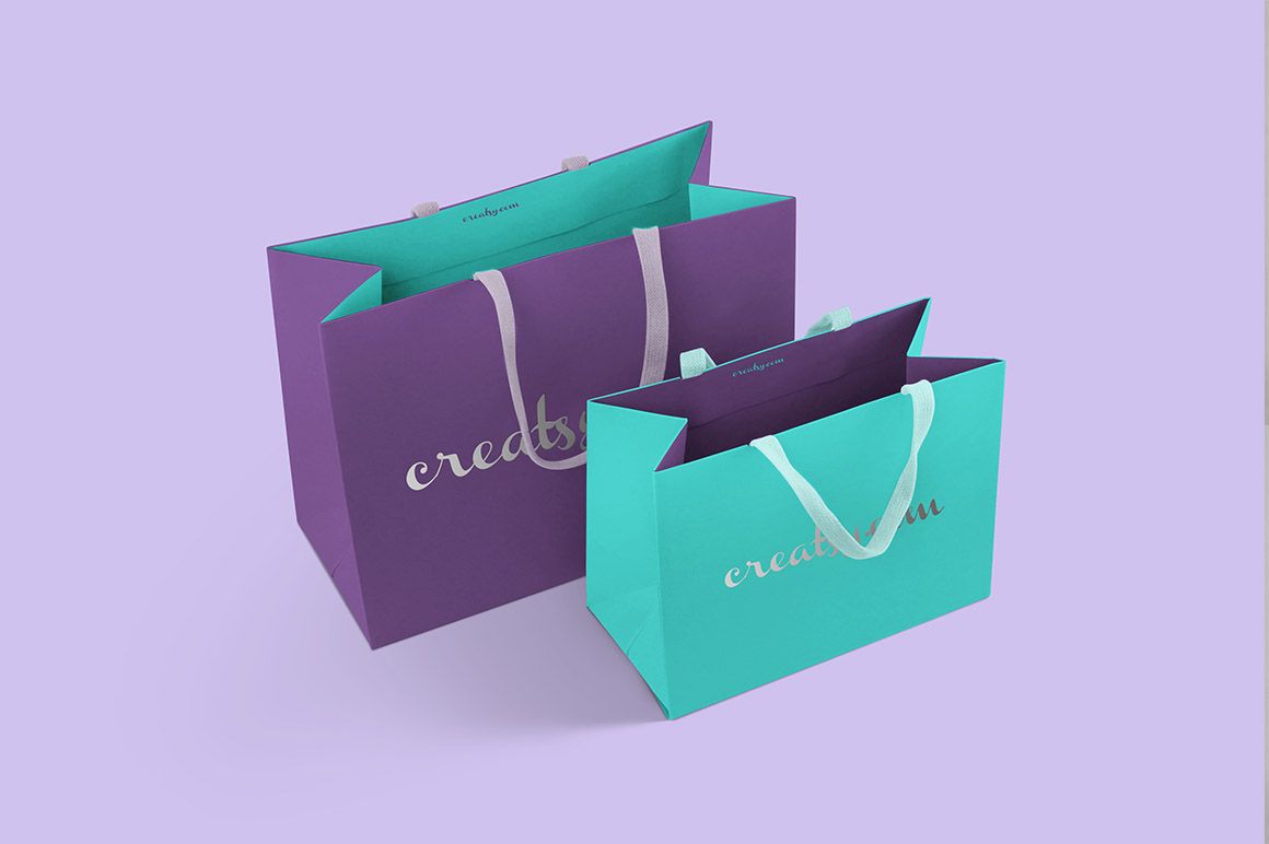 Mockup of two paper bags in different colors, featuring silver text and handles, placed side by side on a pastel background.