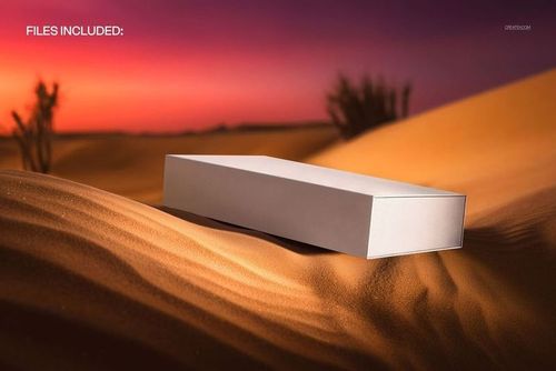 Rectangular sleeve slide box mockup in white resting on golden sand dunes with a vivid sunset sky in the background.