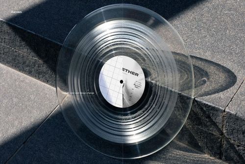 Transparent vinyl record mockup displayed on outdoor stone steps, showing circular grooves and shadow details.