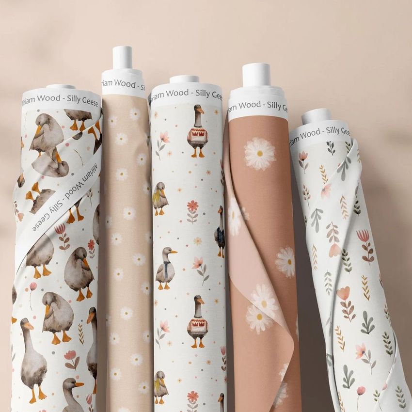 Five fabric rolls mockup standing upright, each featuring playful goose and floral patterns in soft beige, cream, and pastel tones.