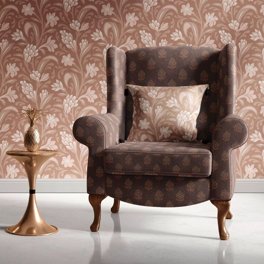 Retro velvet armchair mockup scene with a patterned cushion, set against a floral wallpaper and next to a gold side table.