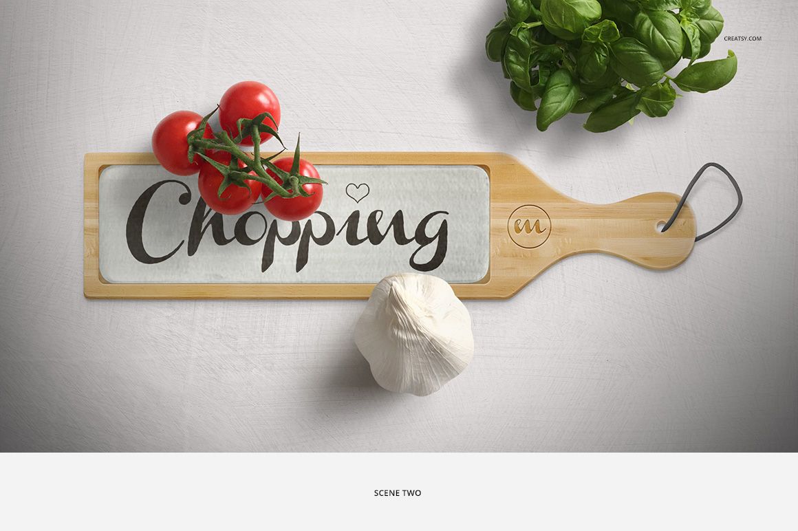 Top view of a chopping board mockup with glass center, fresh tomatoes, garlic bulb, and basil leaves nearby.