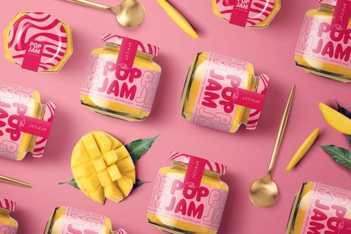 PSD mockup of mango jam jars with bold pink packaging, scattered on a pink background with mango fruit and utensils.