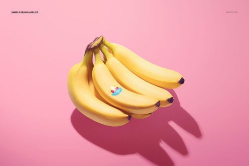 Bunch of yellow bananas with a round fruit sticker on one banana, shown on a pink background in a PSD mockup scene.