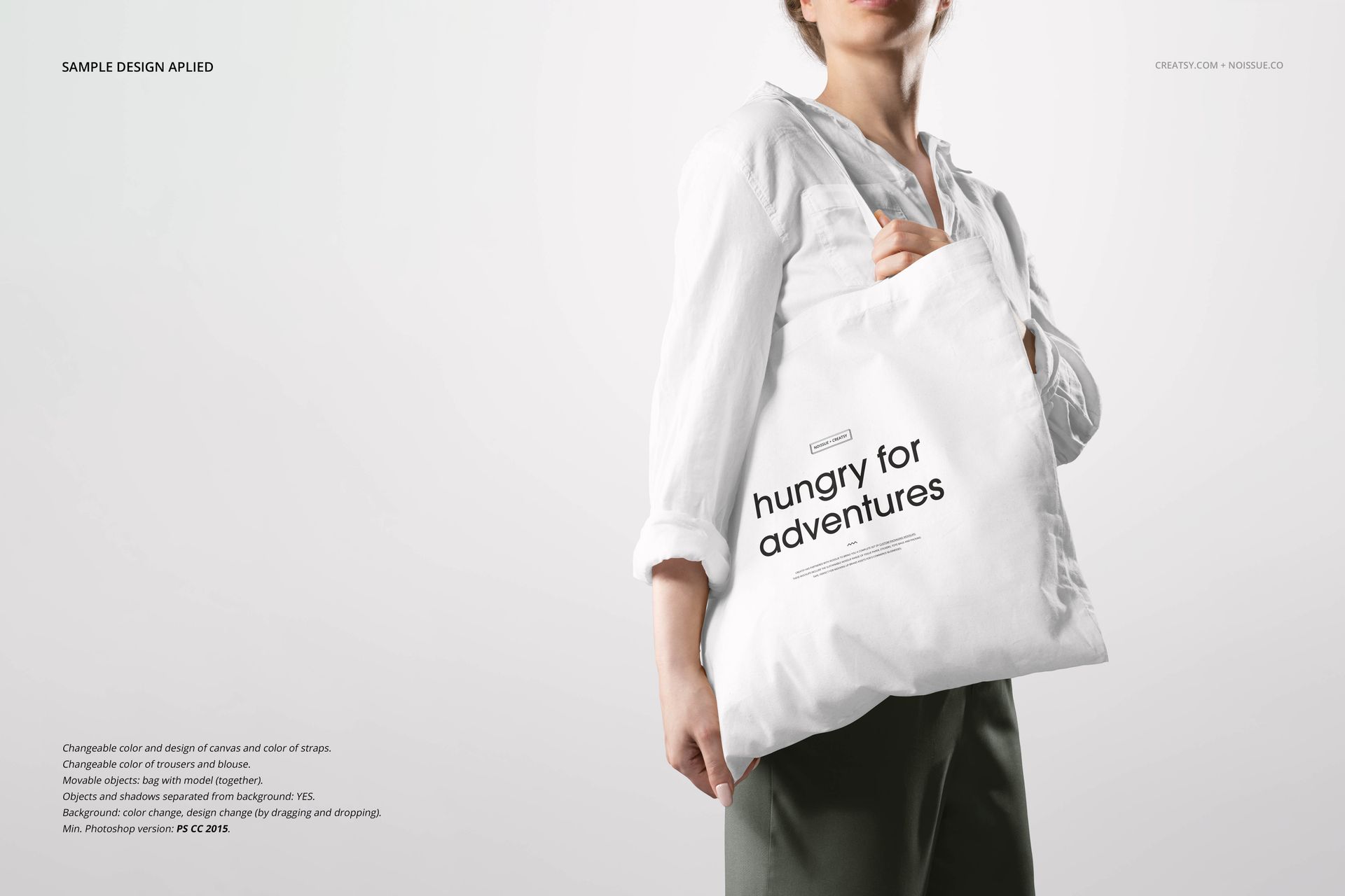 Noissue tote bag PSD mockup showing a white canvas bag with printed text, held by a person in casual attire.