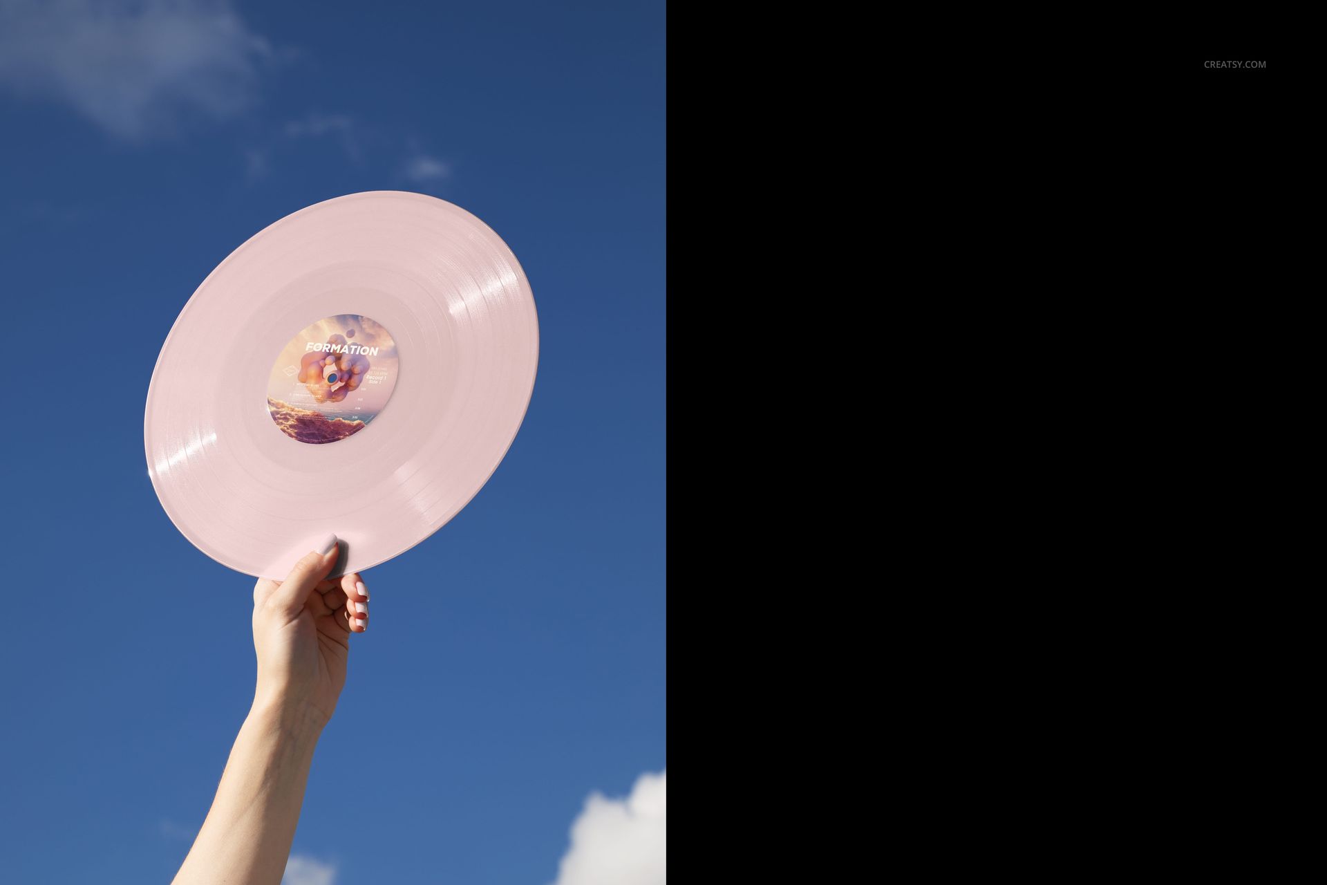 Colored vinyl record mockup featuring a pale pink disc held up outdoors with a blue sky background, PSD format.