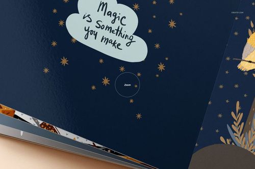 Detailed view of a cardboard baby book mockup showing glossy blue pages with stars and a motivational message.