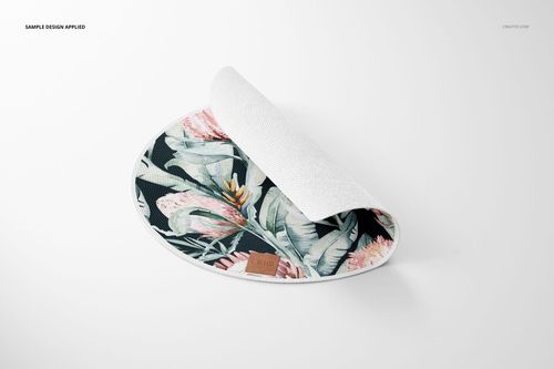 Round knitted rug mockup featuring a botanical design in pastel tones, displayed with one edge lifted on white.