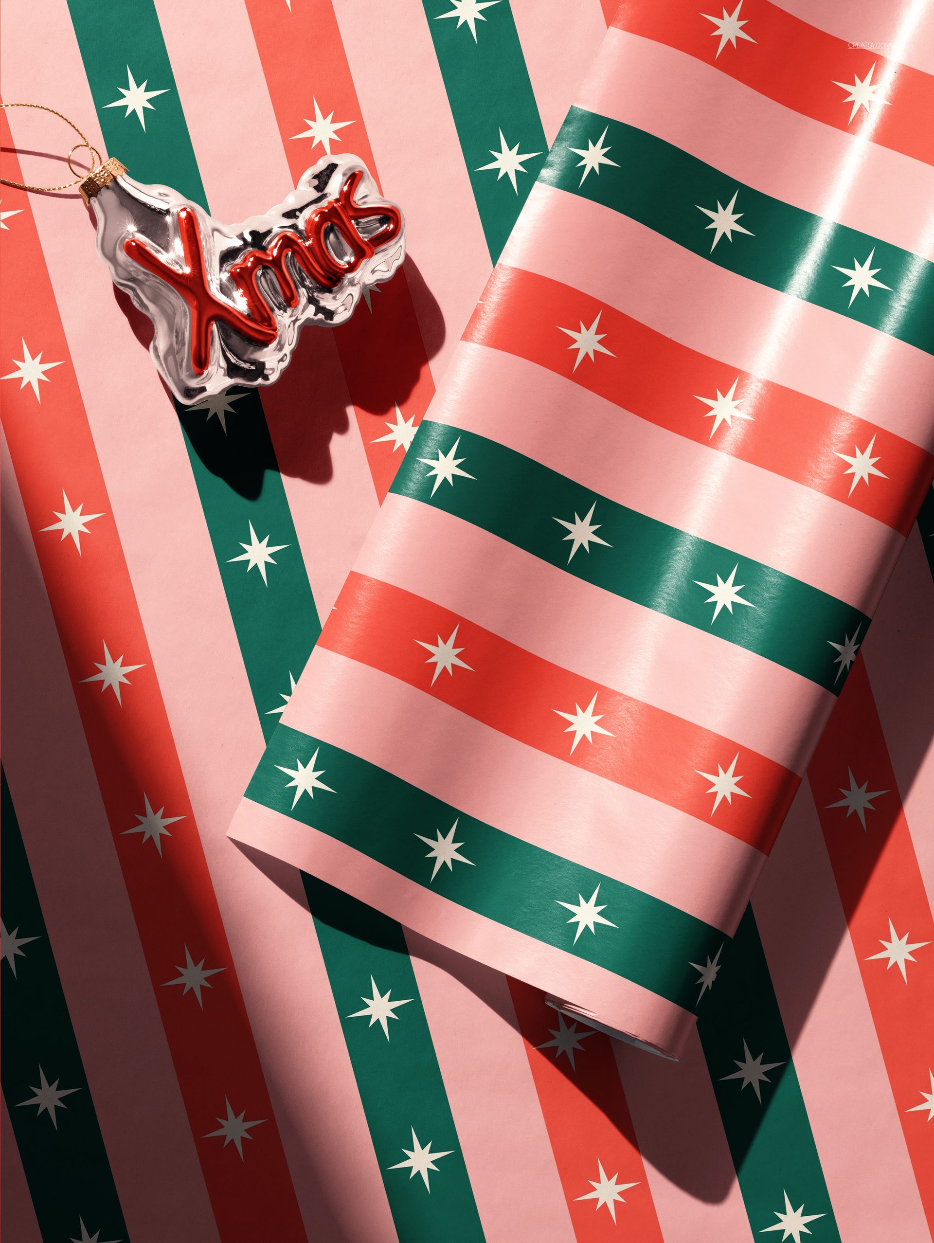 Christmas-themed gift wrapping paper with pink, red, and green stripes and white star patterns, shown in close-up view.
