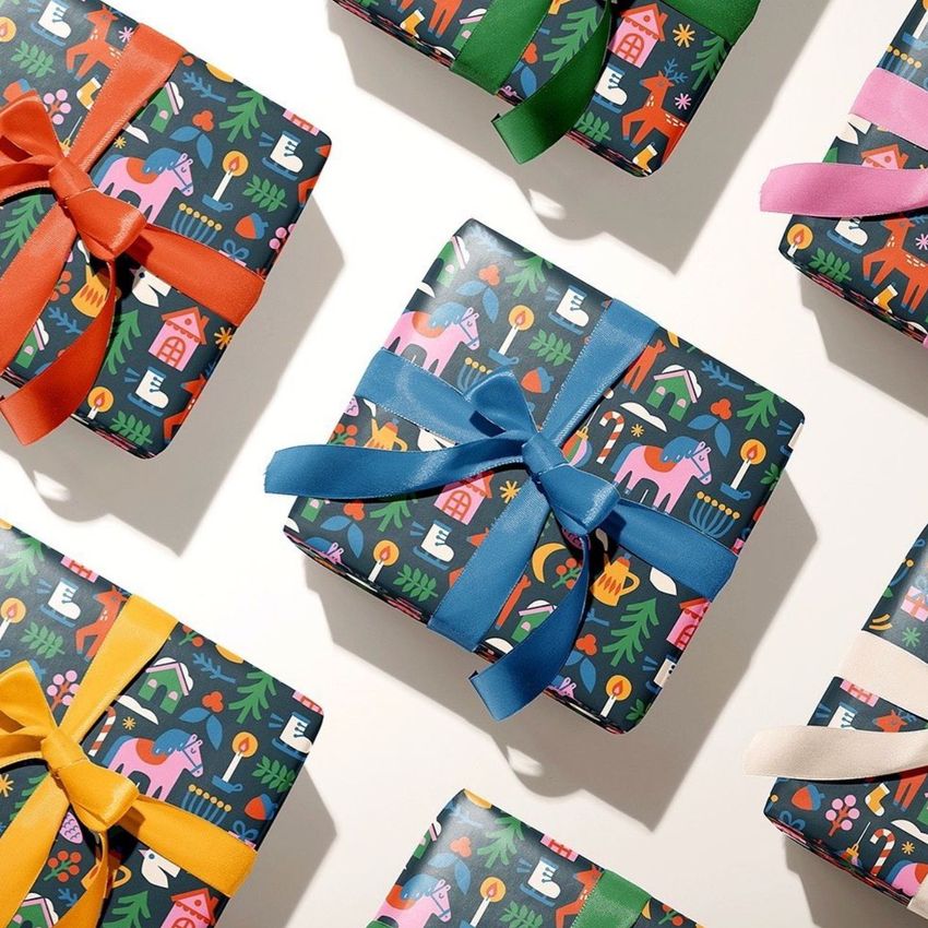 Gift box wrapping paper mockup featuring several square boxes with colorful ribbons and festive Christmas patterns on a white surface.