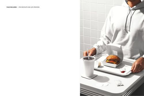 PSD mockup featuring a person at a tiled wall table with a burger, soda cup, and sauce packet arranged on a tray.