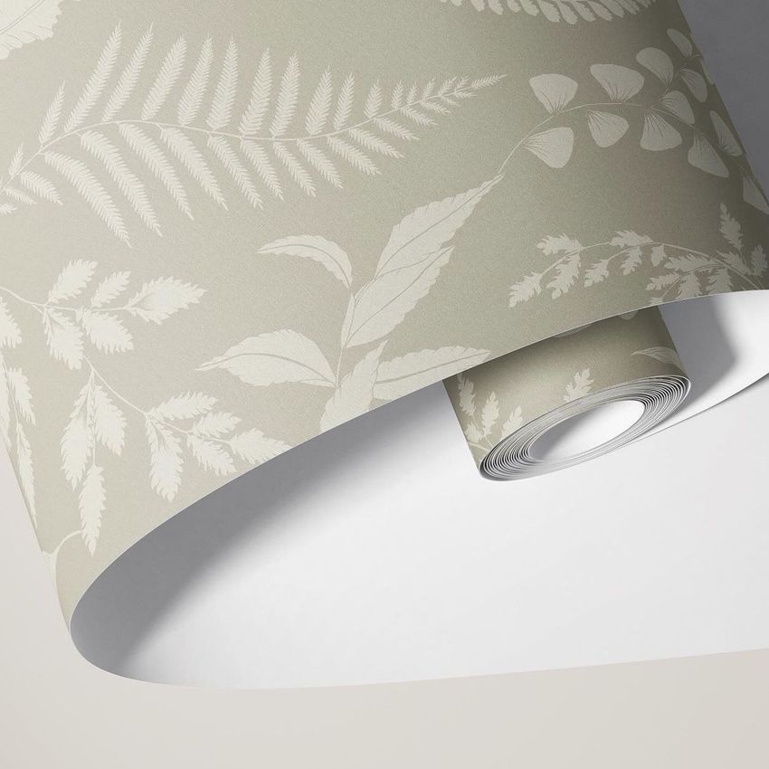Paper wallpaper mockup showing a close-up of rolled wallpaper with a subtle botanical leaf pattern in beige and cream tones.