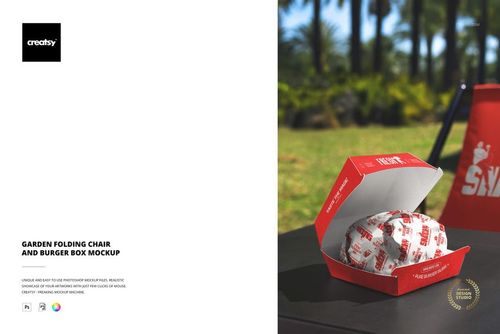 Red and white burger packaging mockup on outdoor table, folding chair and lush garden scene behind.