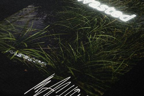 Detailed PSD mockup of a black hoodie showing textured fabric and a vibrant print with illuminated white lettering.