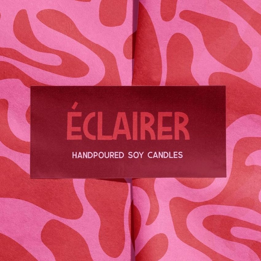Wrapping paper mockup featuring bold pink and red abstract patterns with a rectangular red sticker showing text in the center.