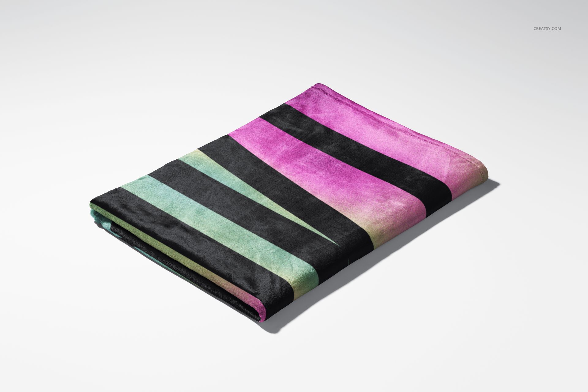 Fleece blanket mockup featuring bold diagonal stripes in black, green, and magenta, displayed folded on white.
