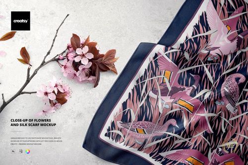 Silk scarf mockup featuring vibrant bird and plant designs, shown next to cherry blossom branches on a pale background.