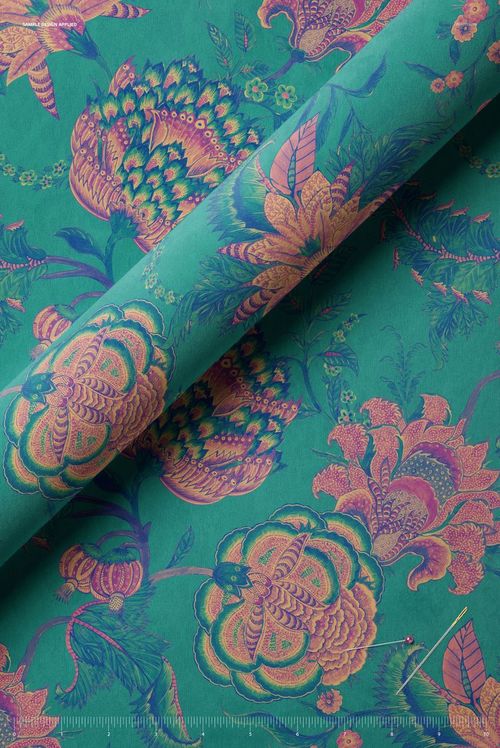 Rolled velvet fabric mockup with intricate flower designs in pink and purple tones, displayed on a teal surface.