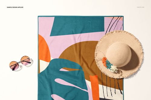 PSD mockup of a rectangular beach towel featuring bold geometric shapes, displayed flat with summer accessories nearby.