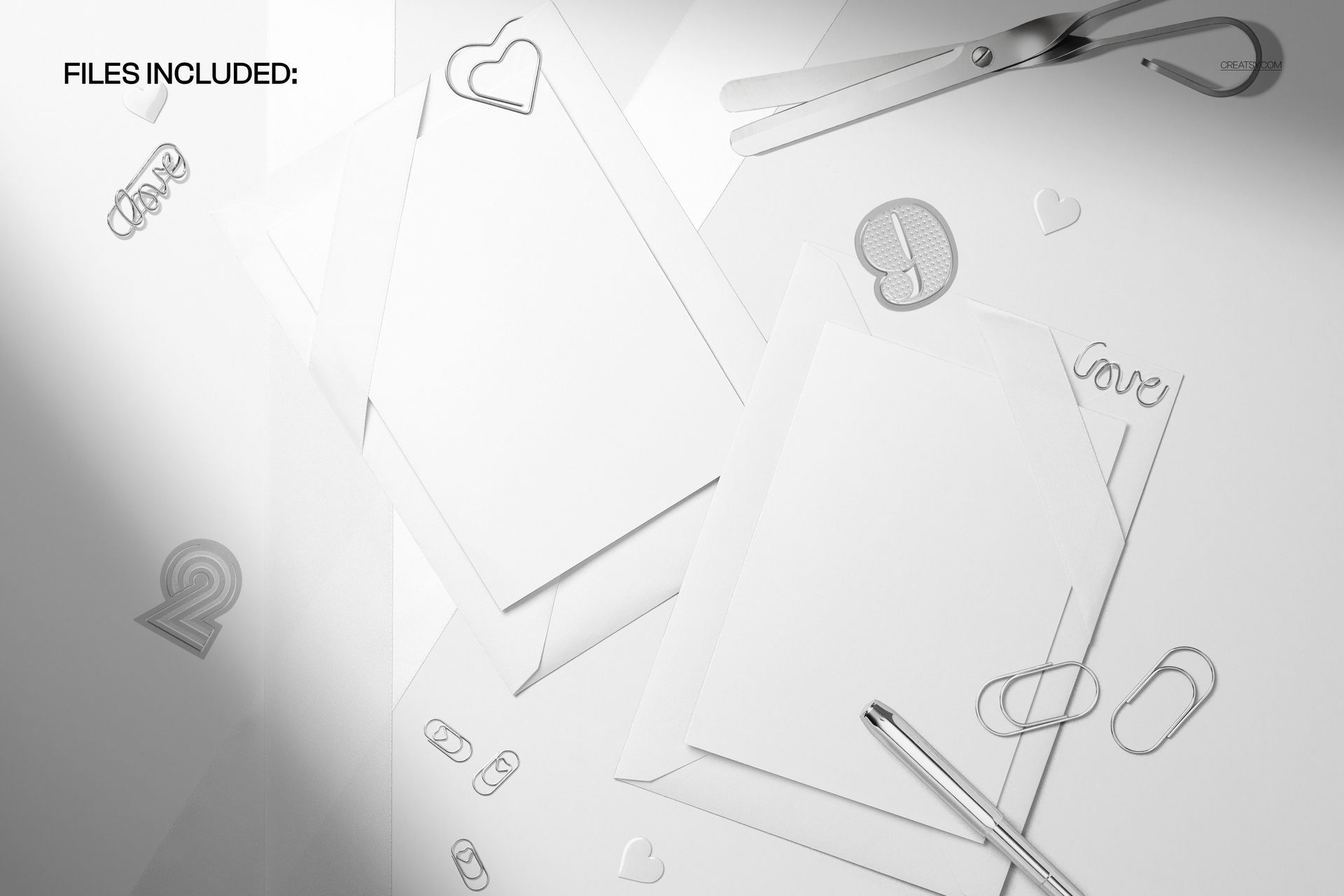 PSD mockup featuring blank stationery cards, envelopes, and decorative paper clips in a minimalist workspace scene.