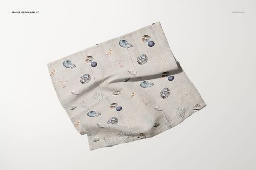 Cotton linen napkin mockup displayed at an angle on a light surface, featuring a subtle marine-themed pattern.